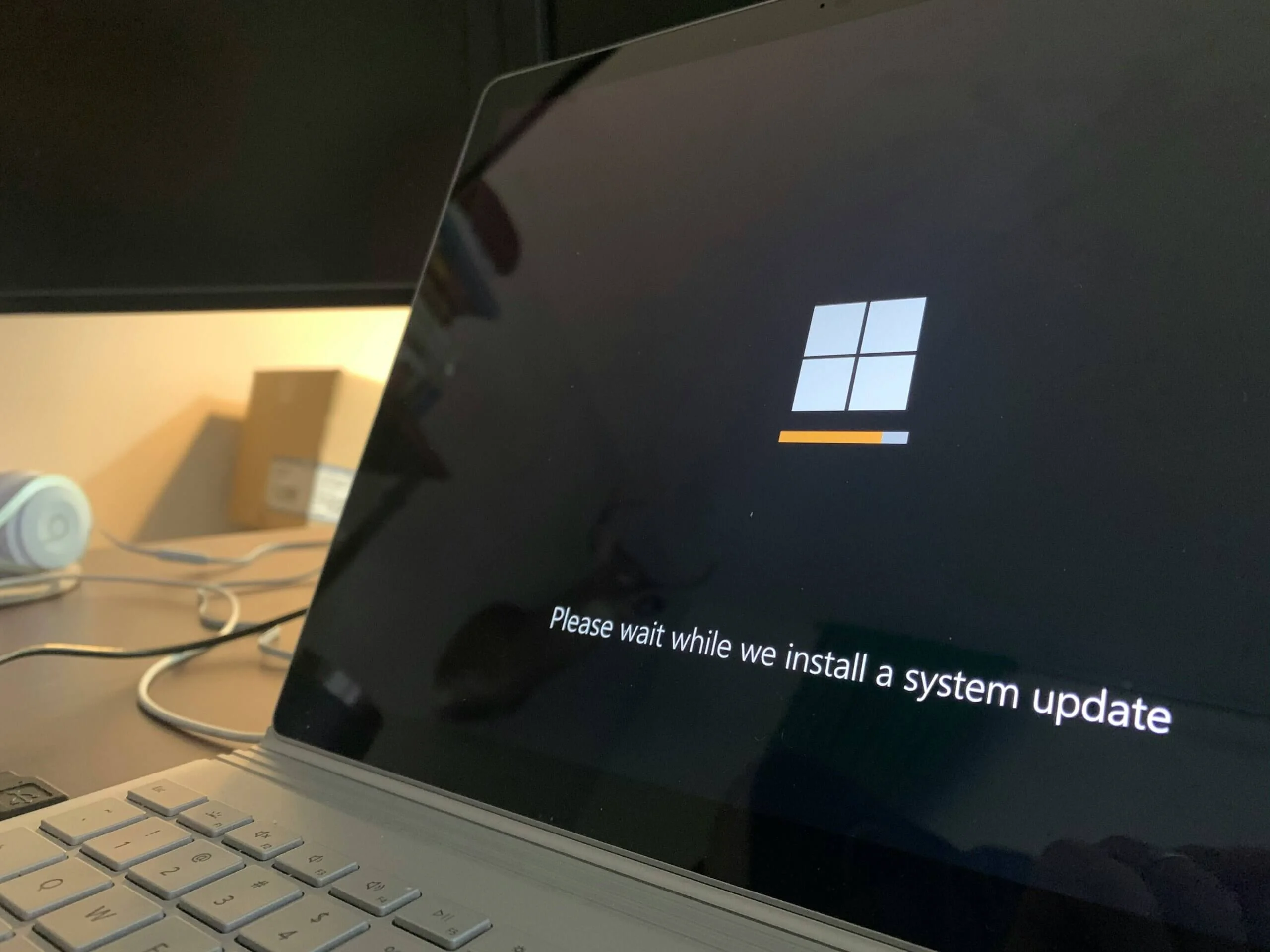 Bildschirm mit dem Logo von Windows mit einem Text drunter der sagt: Bitte warten, es wird eine Systemaktualisierung durchgeführt